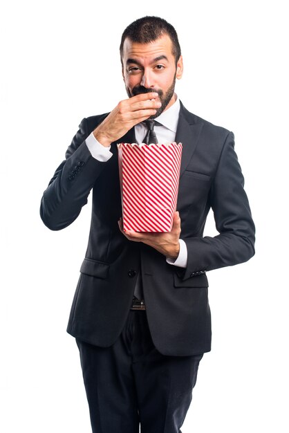 Businessman eating popcorns