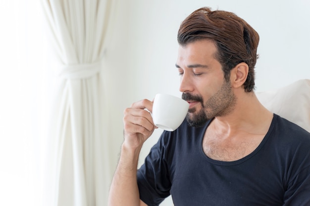 бизнесмен чувствует себя счастливым, пьет кофе во время работы дома
