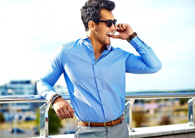 бизнесмен в формальной одежде и солнцезащитные очки, используя свой телефон