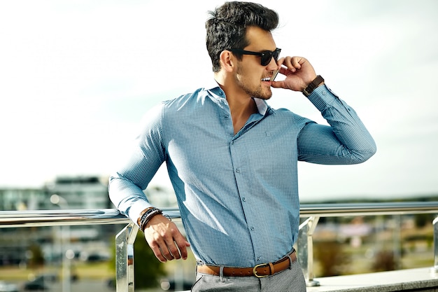 Cheerful male entrepreneur in formal clothes, sits on chair, poses at  camera. Stock Photo by StudioVK