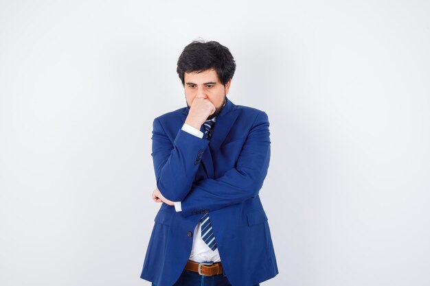 Businessman in formal suit standing in thinking pose and looking pensive , front view.