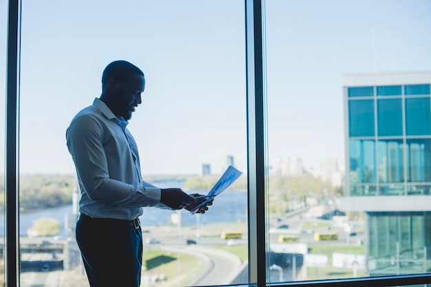 Businessman in front of a window with document