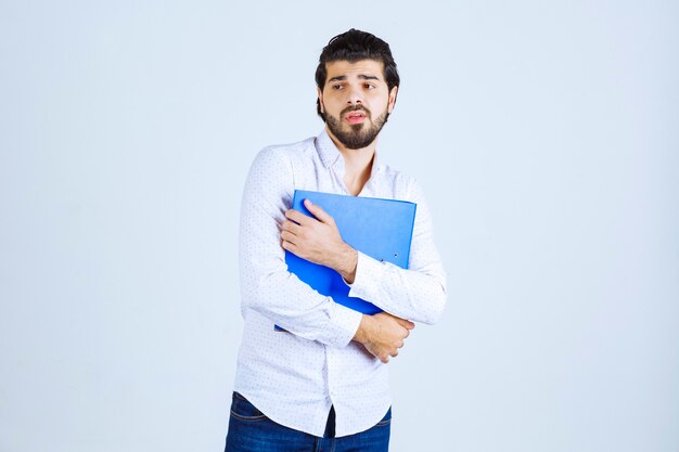 A businessman giving poses with a blue reporting folder