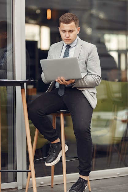 Free photo businessman. guy in a suit. male use a laptop.