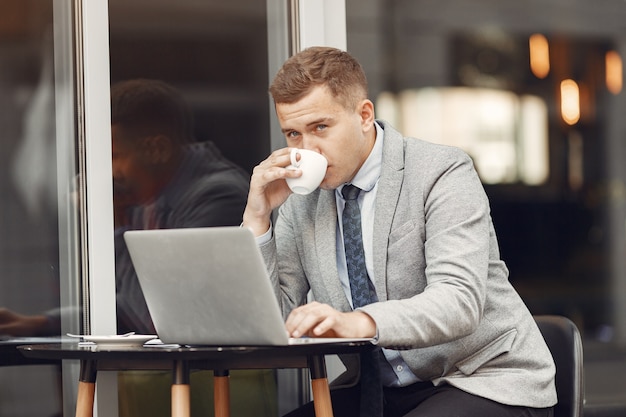 Businessman. Guy in a suit. Male use a laptop.