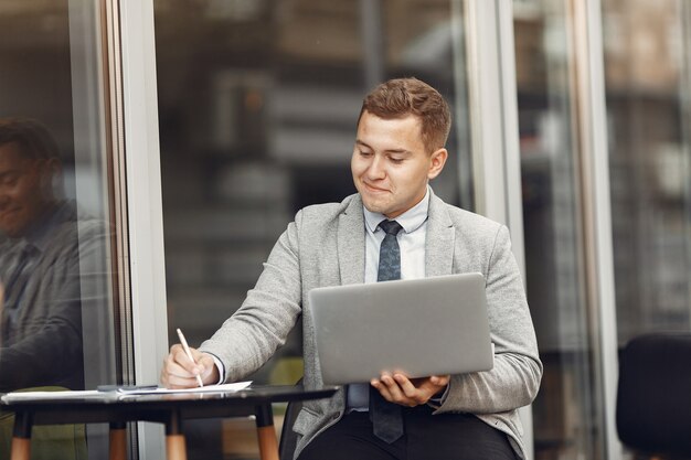 Businessman. Guy in a suit. Malw use a laptop.