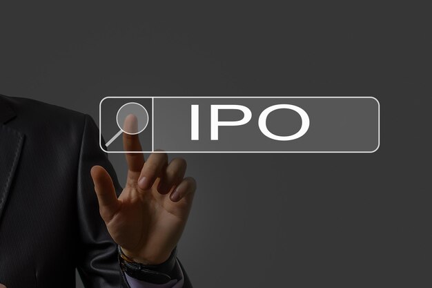 ビジネスマンの手が仮想画面上の IPO 初期公募サインに触れます。