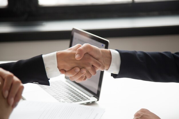 Businessman handshaking businesswoman showing respect, closeup view of hands shaking 