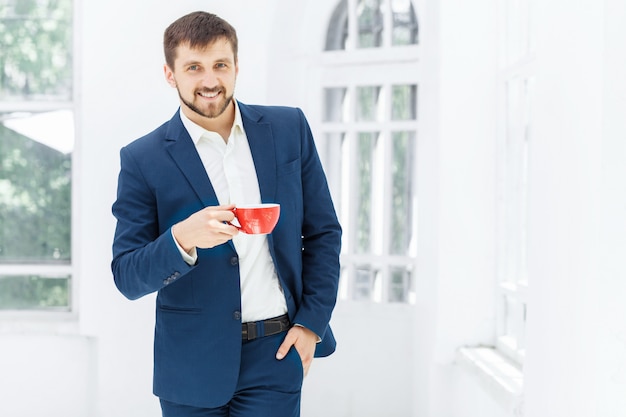 Businessman having coffee break, he is holding a cup