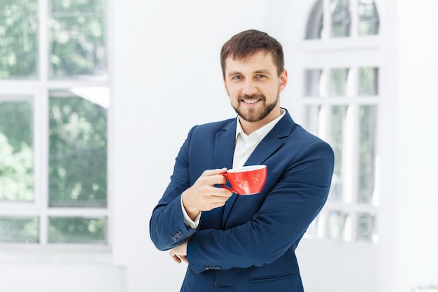 사업가 커피 휴식, 그는 빨간 컵을 들고있다
