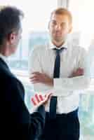 Free photo businessman having conversation with his male partner in office