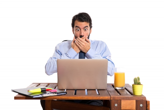 Businessman in his office doing surprise gesture