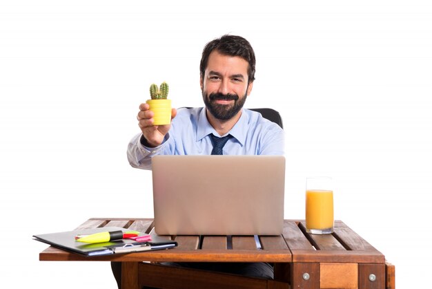 Businessman in his office holding cactus