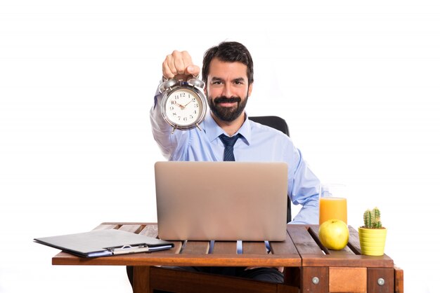 Businessman in his office holding a clock