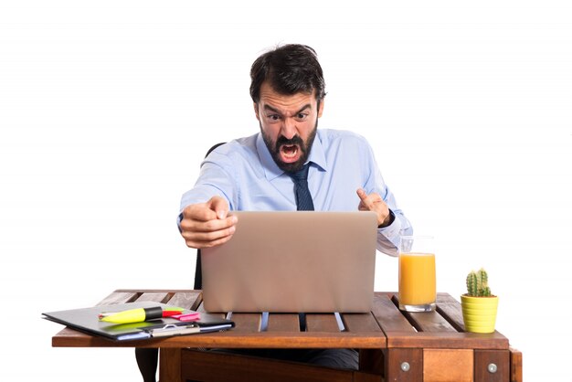 Businessman in his office making horn gesture