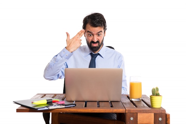 Businessman in his office making suicide gesture