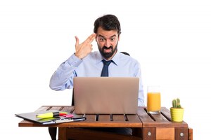 Free photo businessman in his office making suicide gesture