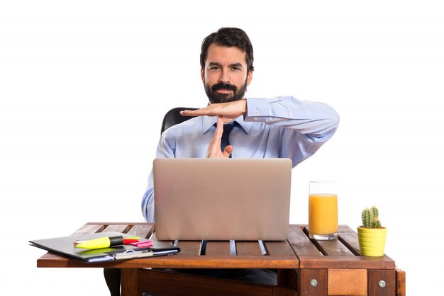 Businessman in his office making time out gesture