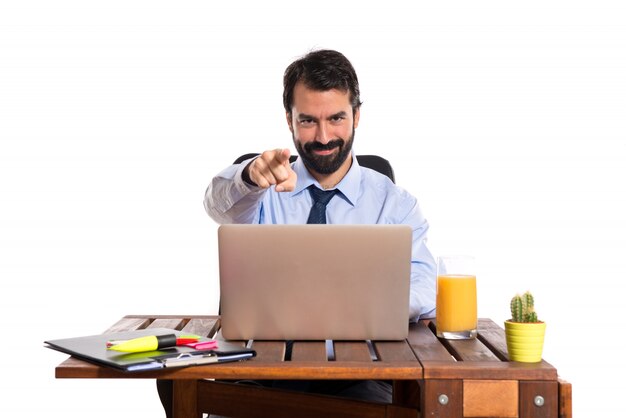 Businessman in his office pointing to the front