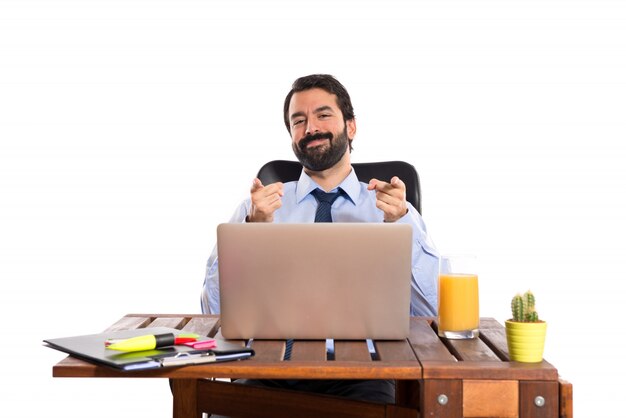 Businessman in his office pointing to the front