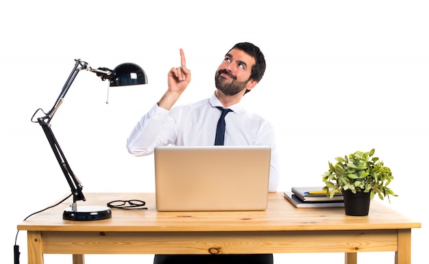 Businessman in his office pointing up