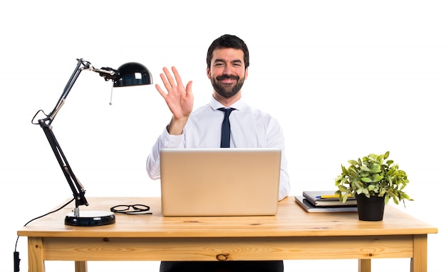 Businessman in his office saluting