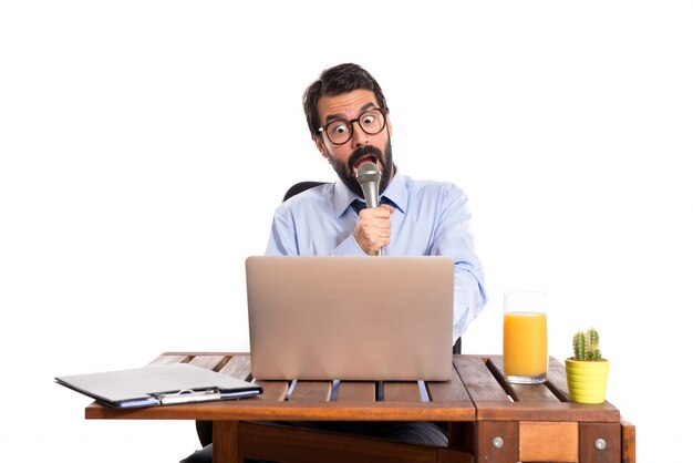 Businessman in his office singing