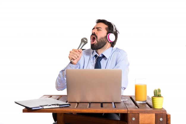 Businessman in his office singing