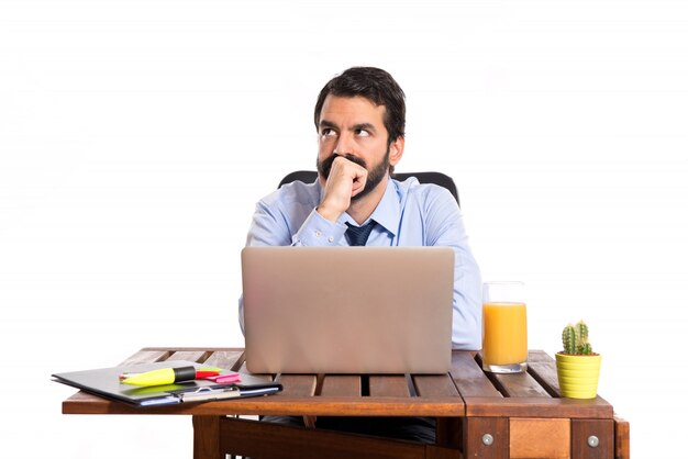 Businessman in his office thinking over white background