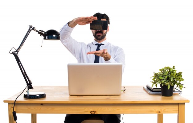 Businessman in his office using VR glasses holding something