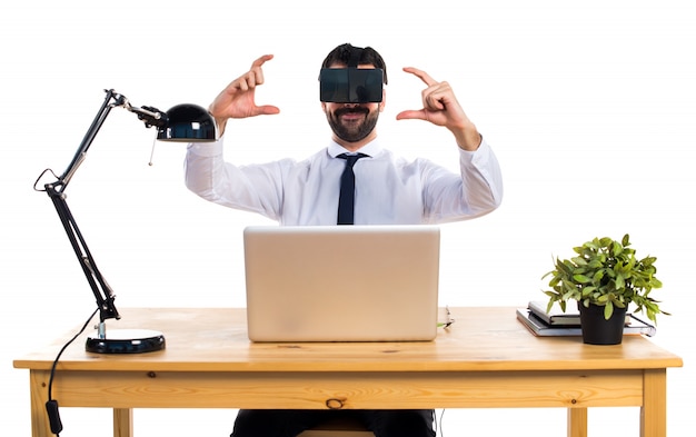 Free photo businessman in his office using vr glasses holding something