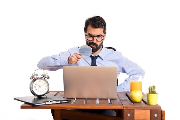 Businessman in his office with magnifying glass