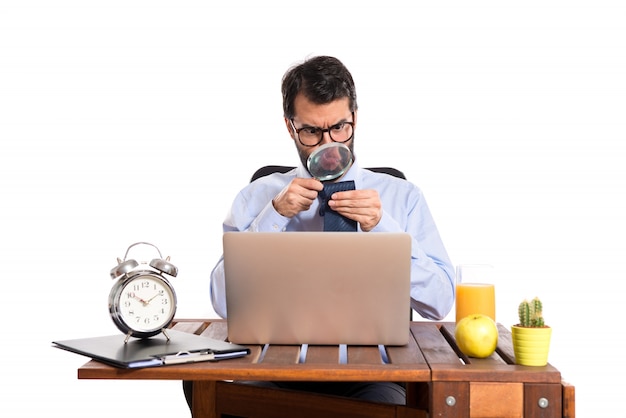 Businessman in his office with magnifying glass