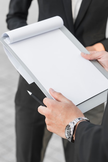 Businessman holding blank clipboard