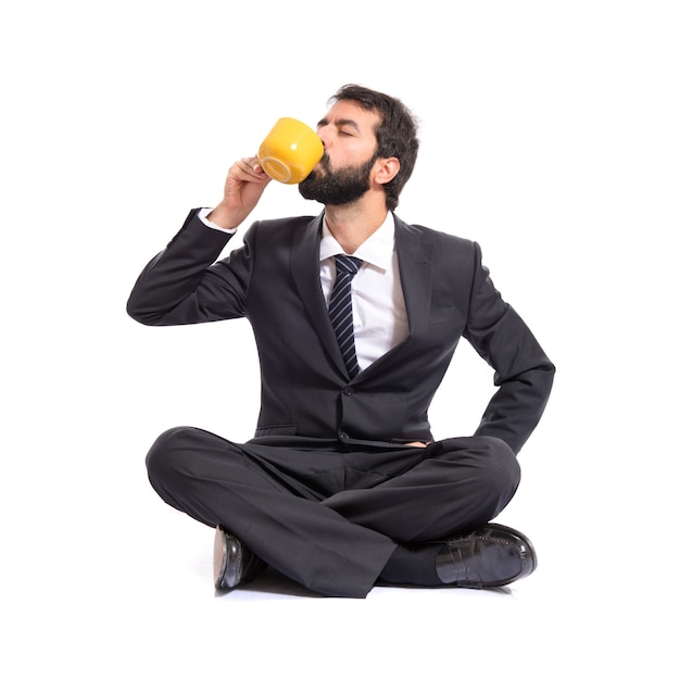 Businessman holding a cup of coffee over white background