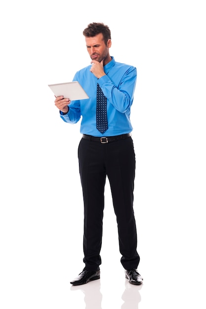 Businessman holding digital tablet and grimacing