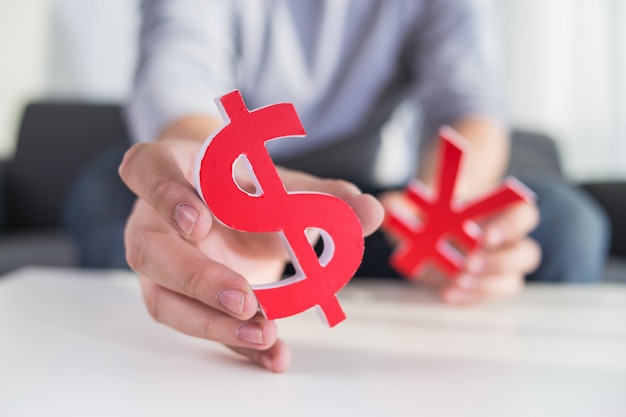 Free photo businessman holding dollar sign and cny sign