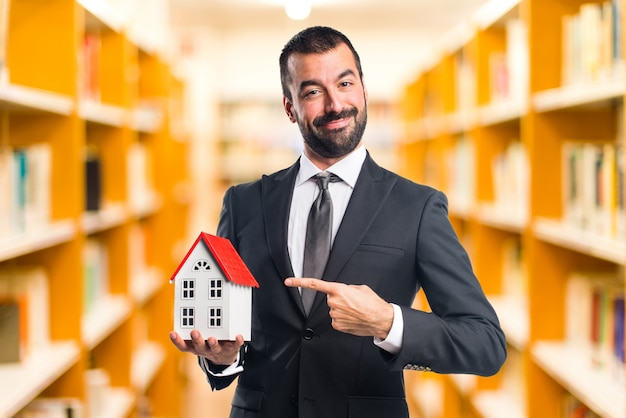 Free photo businessman holding a little house