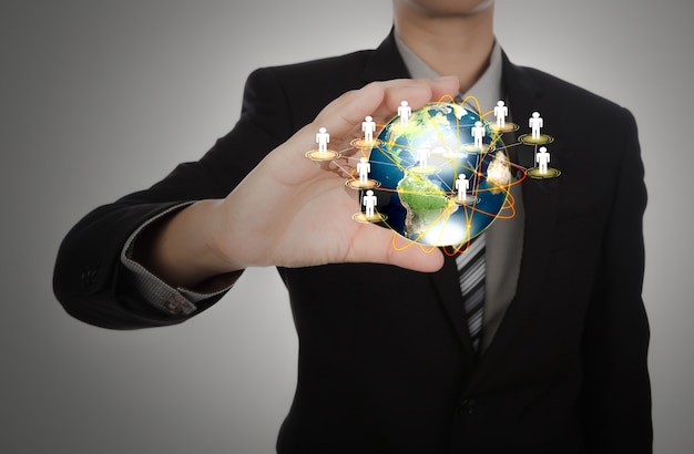 Free photo businessman holding a planet earth with people symbols