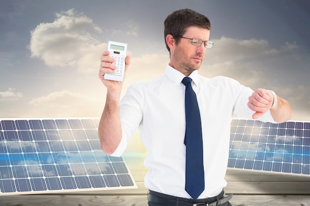 Free photo businessman holding a remote and looking at his watch