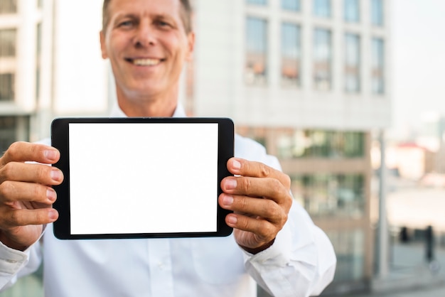 Free photo businessman holding tablet mock-up