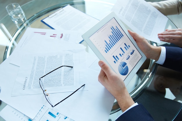 Businessman holding a tablet with statistical data