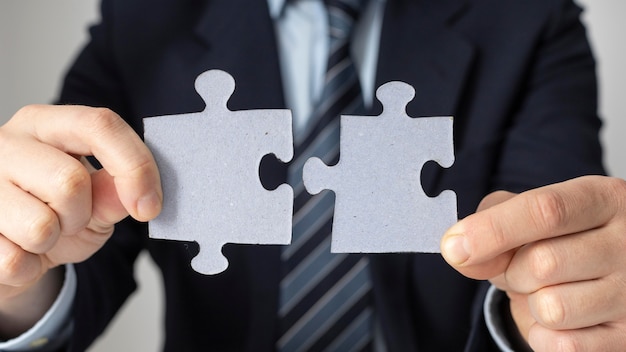 Businessman holding two puzzle pieces