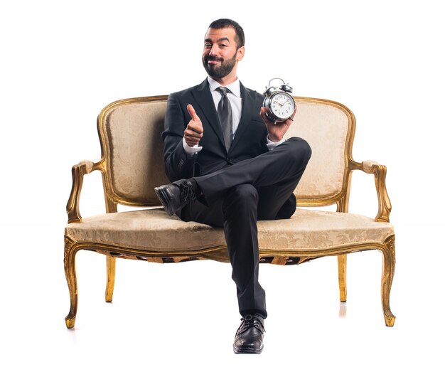 Businessman holding vintage clock