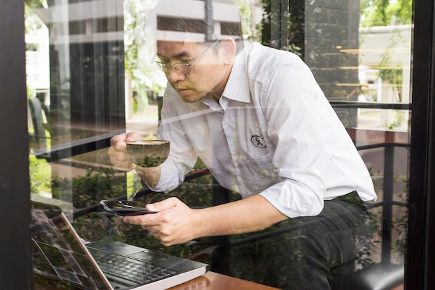 Foto gratuita l'uomo d'affari sta lavorando con il suo computer nella caffetteria