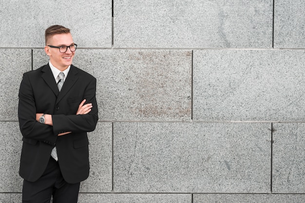 Free photo businessman leaning against wall