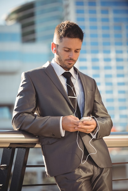 Businessman listening to music and using