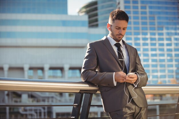 Businessman listening to music and using