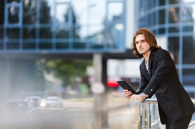 Businessman looking away while holding a tablet