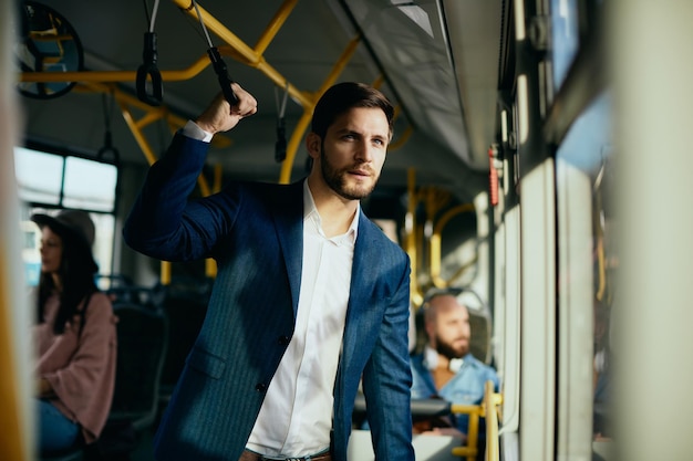 Businessman looking through the window while traveling by public bus